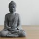 Graue Buddhafigur auf Holz mit weißem Hintergrund