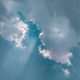 Blauer Himmel mit Wolken und Sonnenstrahlen