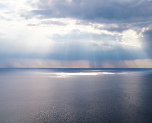 Meer und Wolkenhimmel mit Sonnenstrahlen