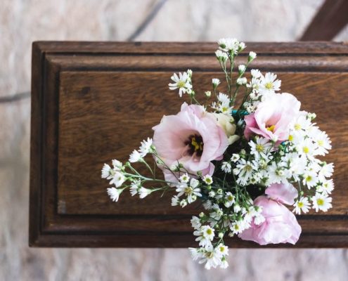 Holzsarg für Erdbestattung mit Blumenarrangement